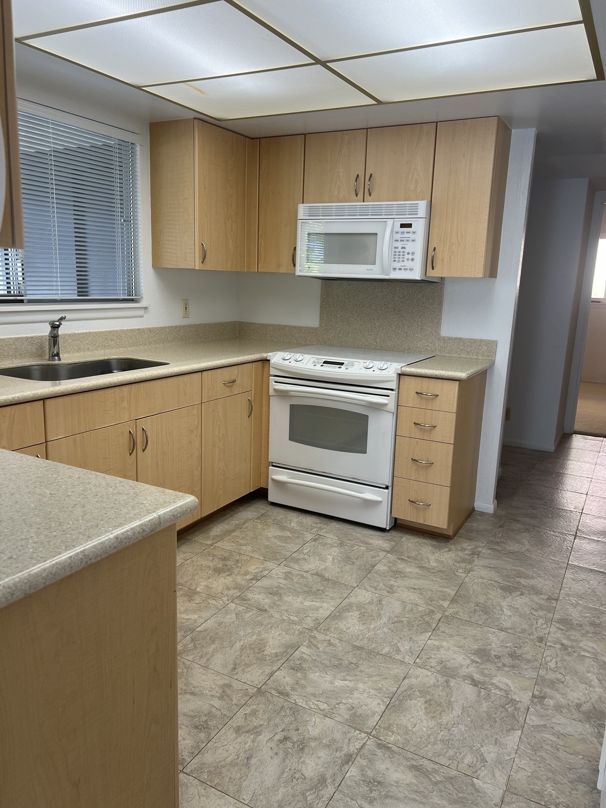 A kitchen with a white oven and microwave.